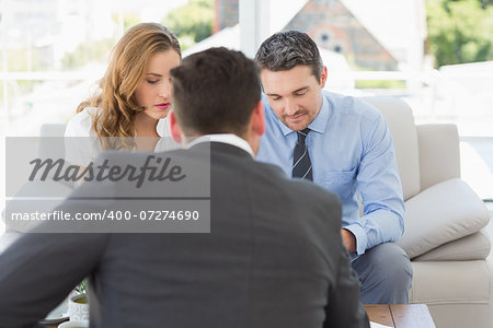 Young couple in meeting with a financial adviser in the living room at home