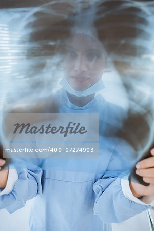 Closeup of a female surgeon examining blurred x-ray in the hospital