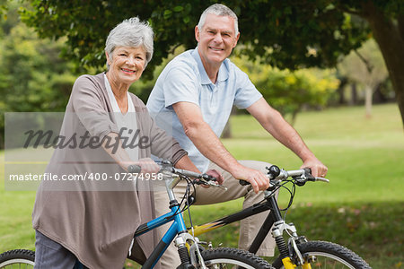 Side view portrait of a senior couple on cycle ride in countryside