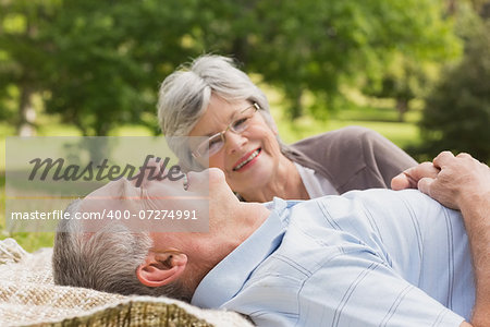 Side of a senior woman and man lying at the park