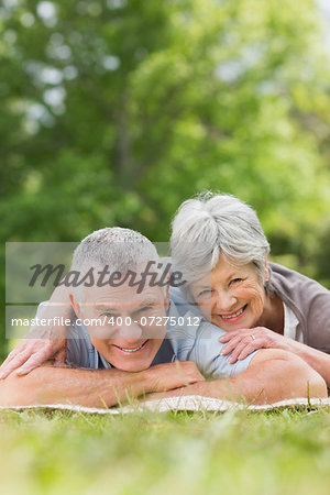 Portrait of a smiling relaxed senior couple lying in the park