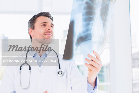 Serious male doctor examining xray in the medical office