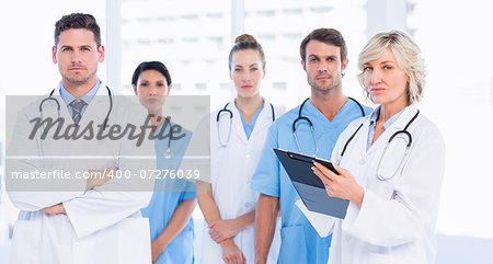 Portrait of serious confident group of doctors standing at the medical office