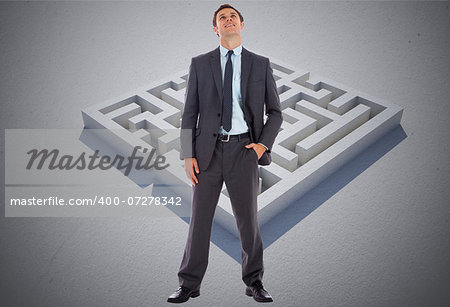 Happy businessman with hand in pocket against maze puzzle