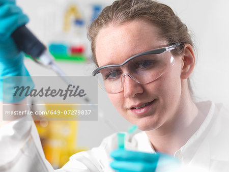 Laboratory worker pipetting sample into an eppendorf vial Laboratory worker pipetting sample into an eppendorf vial