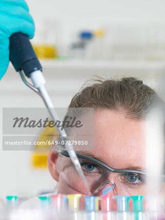 Scientist pipetting sample into an eppendorf vial in laboratory Scientist pipetting sample into an eppendorf vial in laboratory