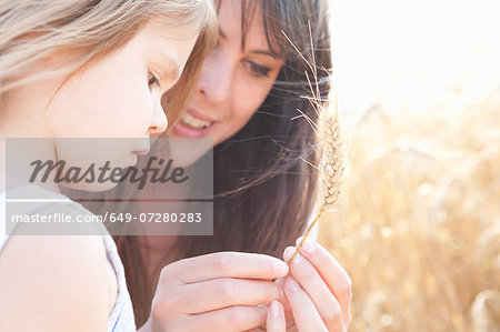 Mother and daughter looking at grain of wheat