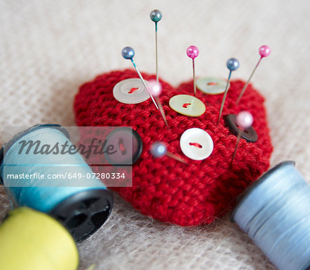 Heart-shaped pin cushion. buttons and thread