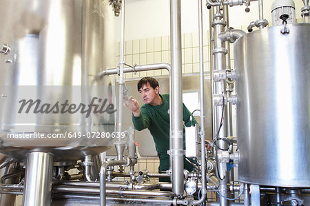 Brewery worker operating machine