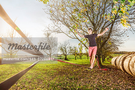 Portrait of young man walking on slackline