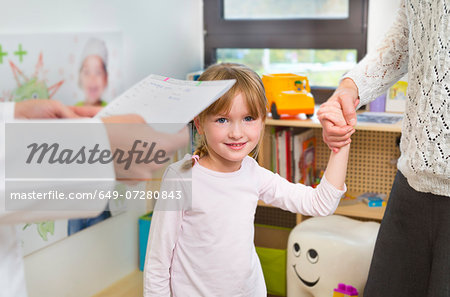 Girl holding hands with mother at dentists