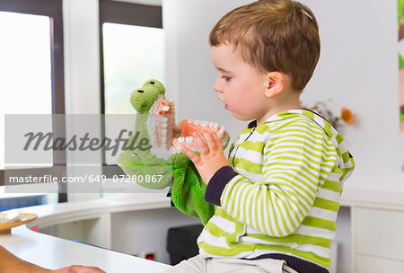Boy playing with toy crocodile in dentists
