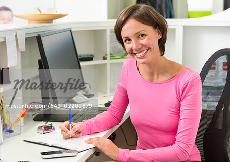 Receptionist writing at desk