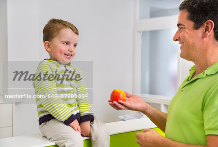 Man giving young boy apple