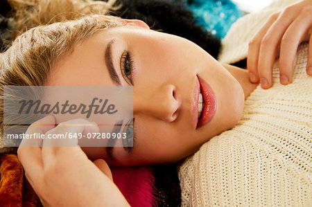 Close up portrait of young woman lying on furry blanket