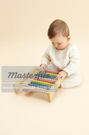 Studio portrait of baby girl playing with abacus