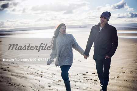 Young couple holding hands, Brean Sands, Somerset, England