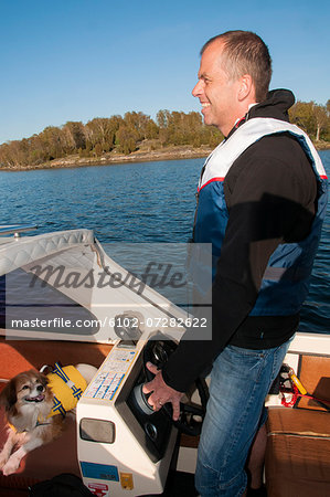 Smiling man with dog on boat, Ronneby, Blekinge, Sweden