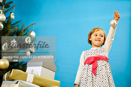 Little girl holding Christmas bauble, Munich, Bavaria, Germany
