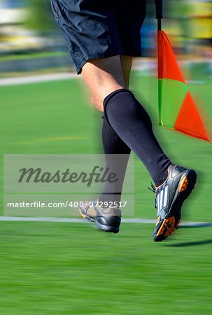 Soccer line referee running with flag