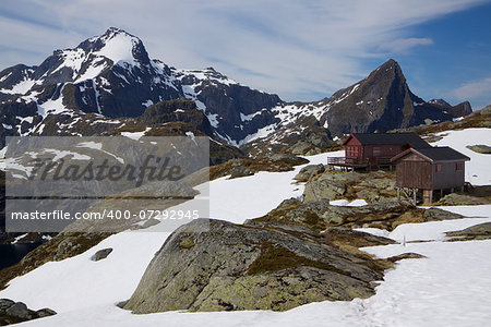 Mountain hut and highest peak of west Lofoten islands Hermannsdalstinden in the background in early summer