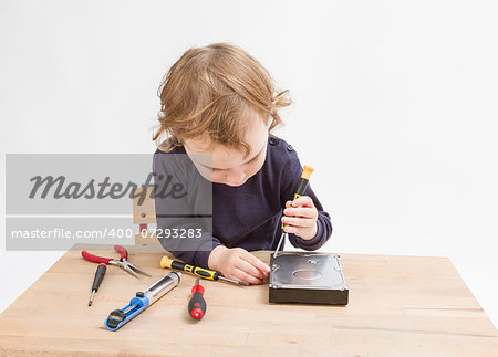 young child opening hard drive with screwdriver