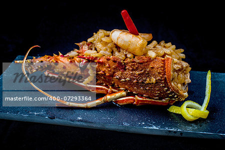 spanish rice with prawn and vegetables served on black tray