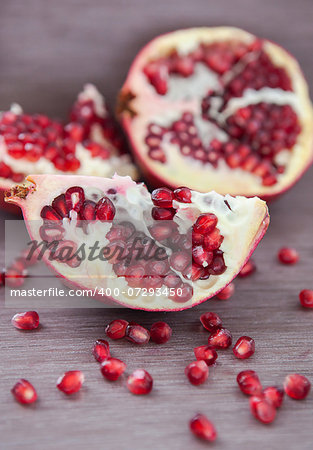 Pomegranate and pomegranate seeds on a wooden board