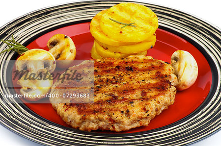 Roasted Turkey Steak with Grilled Sliced Potato and Portabello Mushrooms closeup on Striped Red Plate