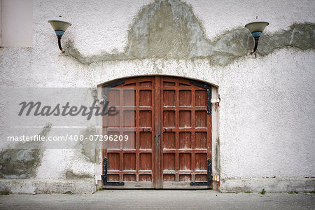 Old wooden gate in grungy gray wall