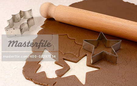 Making gingerbread cookies with cutter and wooden rolling pin