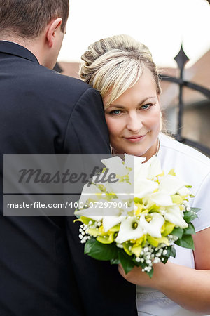 beautiful young wedding couple, bride with her groom and wedding bouquet