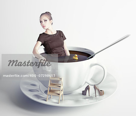 little beautiful woman takes a bath in cup of coffee (creative concept)