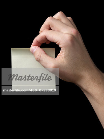 adult man hand holding sticky note, isolated on black