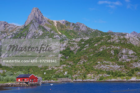 Typical red fishing hut in fjord on Lofoten islands in Norway