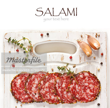 Sliced salami on a kitchen cutting board.