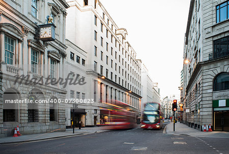 Red Bus in motion in City of London on contemporary buildingd