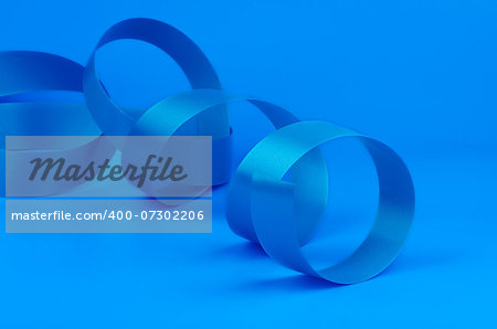 Blue Curly Silk Ribbon isolated on Blue background