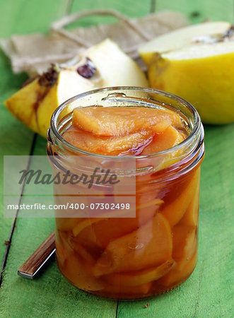 quince jam confiture in  glass jar on a wooden table