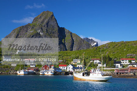 Picturesque town of Reine with fishing boats in the fjord on Lofoten islands in Norway