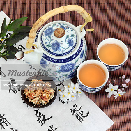 Jasmine flower tea with oriental style teapot, cups and spoon and chinese calligraphy. Su xin hua.