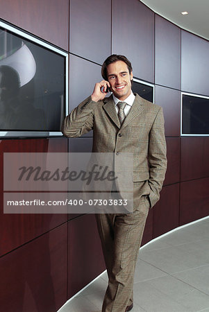 Businessman with mobile phone in front of modern building