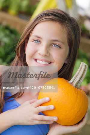 Pretty Young Girl Having Fun with the Pumpkins at the Market.