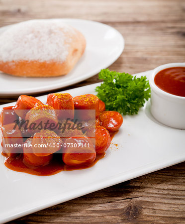 curry wurst spicy sausage with curry and ketchup on wooden background