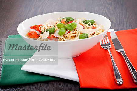 fresh tasty pasta spaghetti with tomatoes parmesan and basil on table