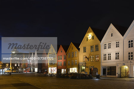 illuminated old street of Bergen, Norway. There is a row of wood multicoloured old houses.