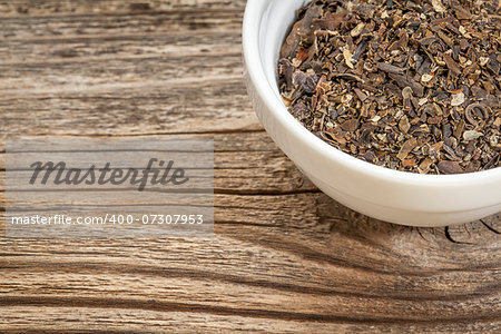 a bowl of bladderwrack seaweed against grained wood with copy space