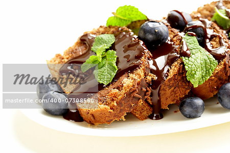 chocolate biscuit roll garnished with mint leaves and blueberries