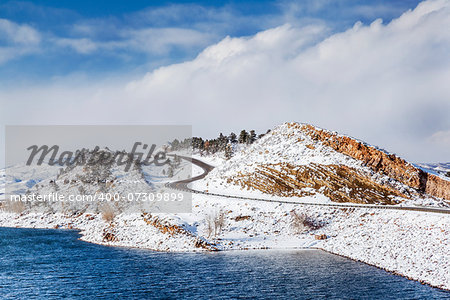 mountain lake, rock cliff, dam and windy road in winter scenery - Horsetooth Reservoir near Fort Collins, Colorado