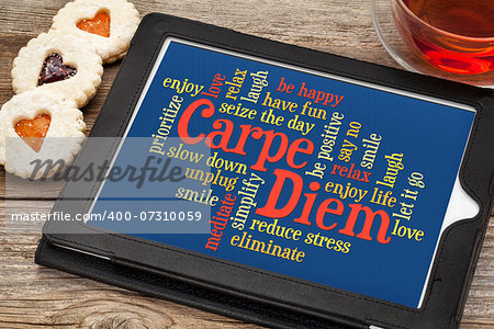 Carpe DIem and positivity word cloud on a digital tablet with tea and heart cookies